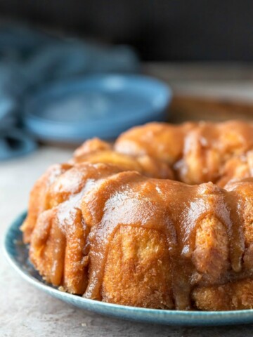 Platter of monkey bread on a blue plate next to two blue plates