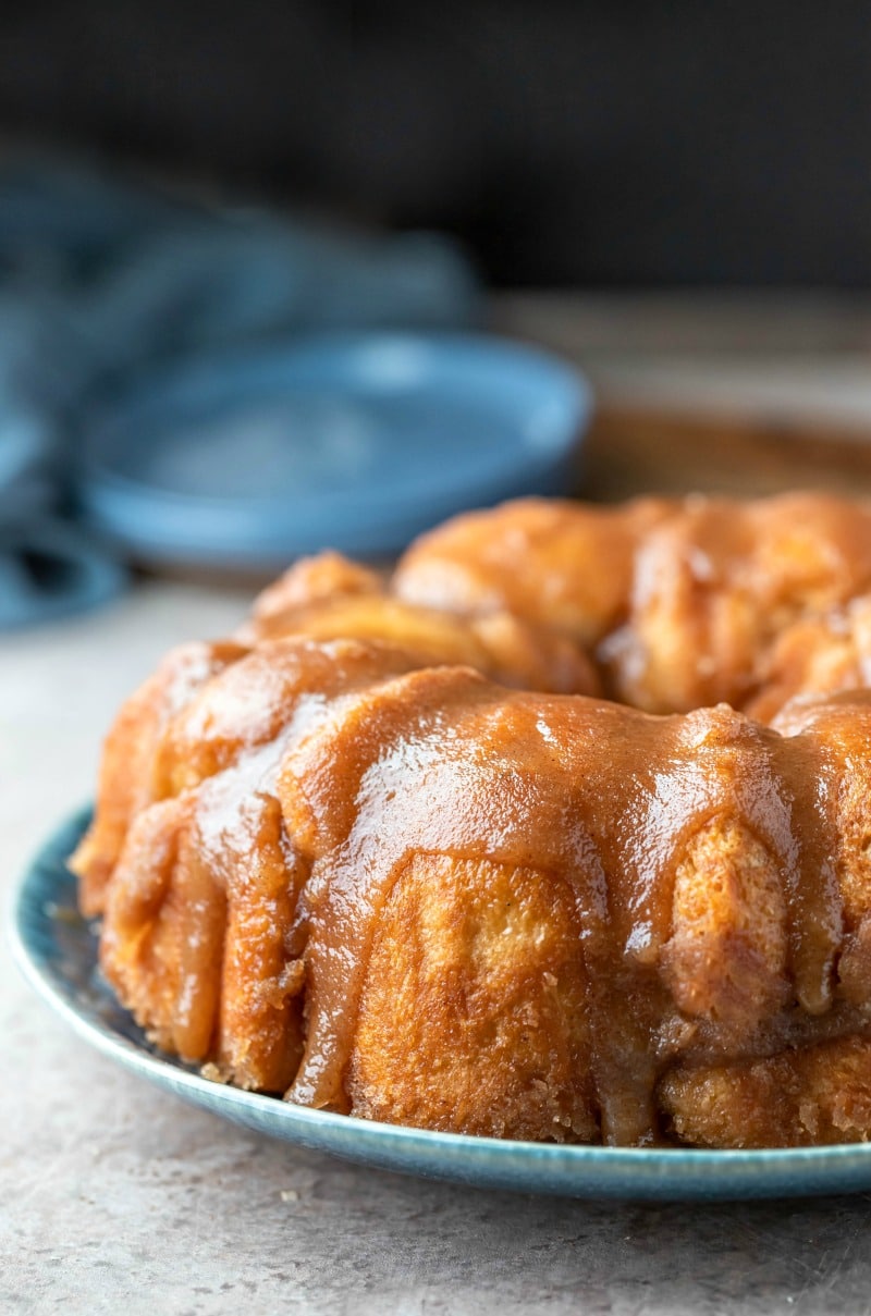 Platter of monkey bread on a blue plate next to two blue plates