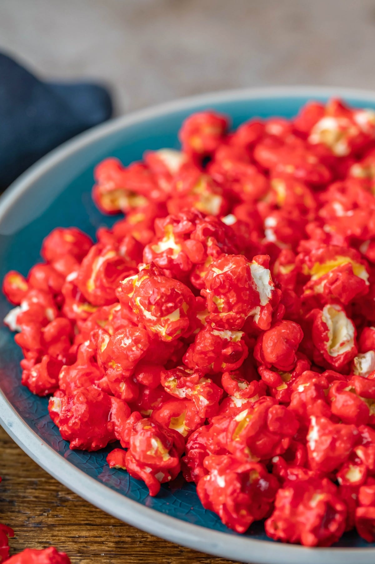 Front view of red hot cinnamon popcorn on a blue plate