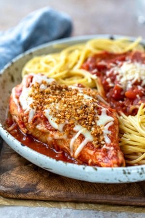 Slow cooker chicken parmesan on a speckled plate