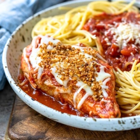 Chicken parmesan and spaghetti on a speckled plate