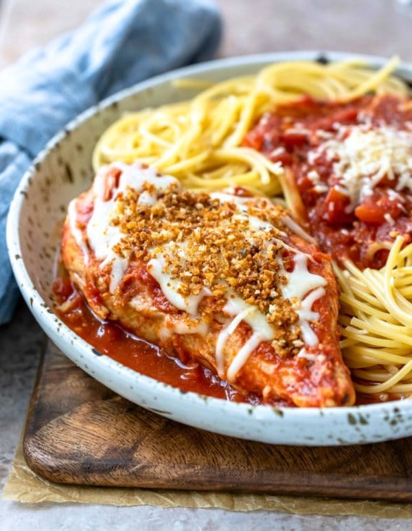 Chicken parmesan and spaghetti on a speckled plate