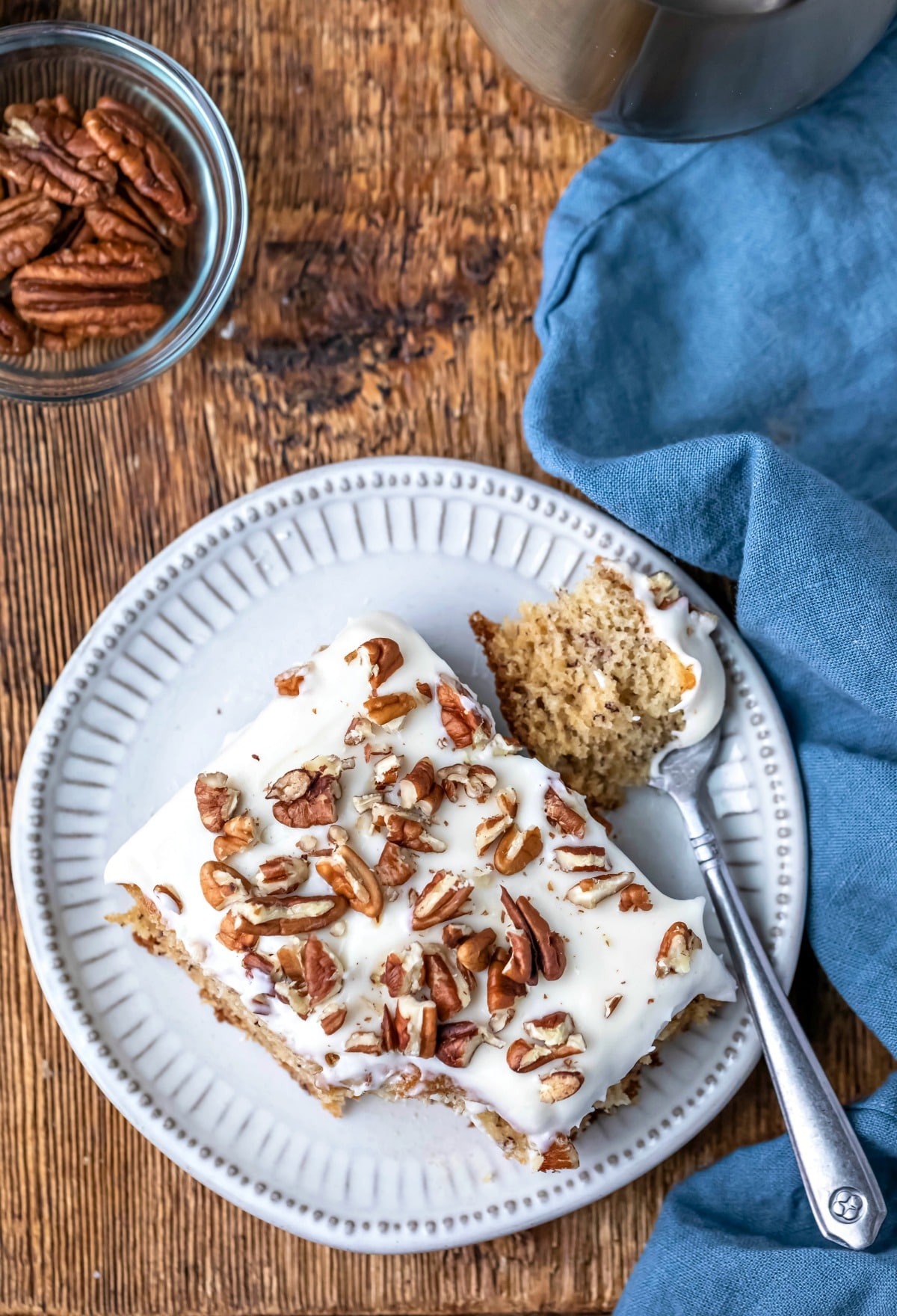 Overhead photo of a slice of banana cake with a bite on the fork next to it