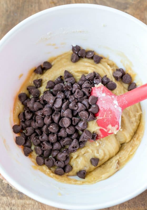 Chewy chocolate chip cookie bar dough in a bowl with chocolate chips on top