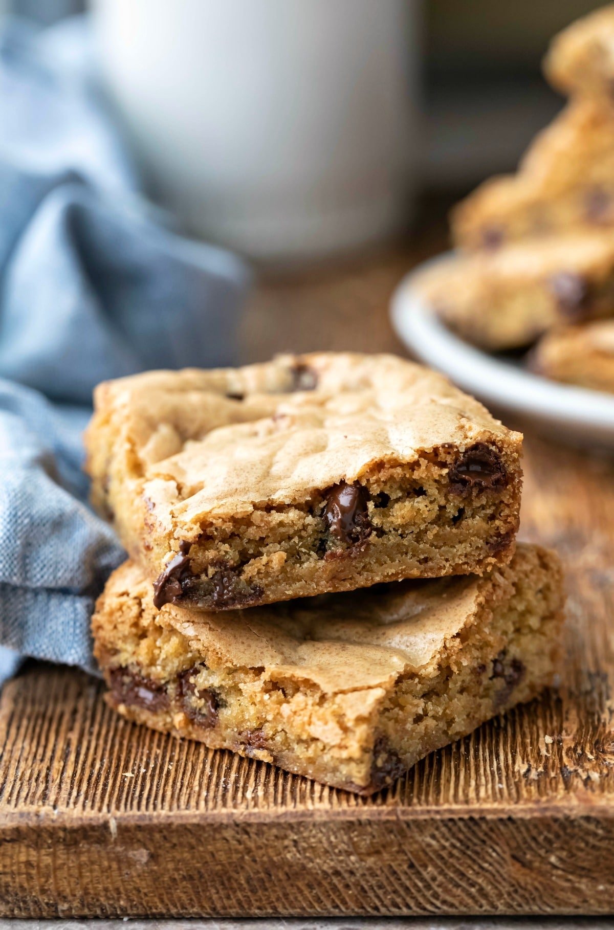Two chocolate chip cookie bars on a wooden cutting board