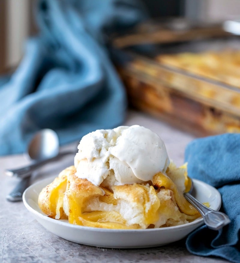 Dish of peach cobbler with a silver spoon in it