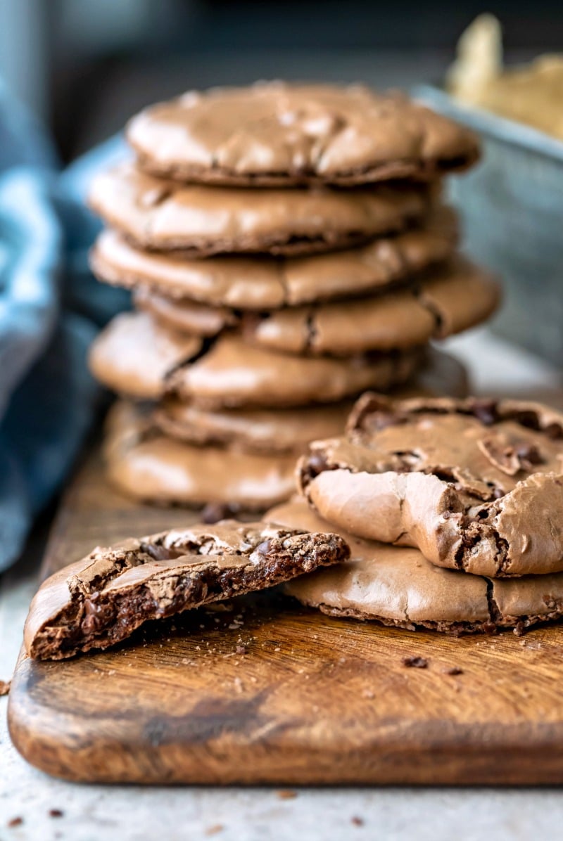 Stack of flourless fudge cookies on a wooden cutting board