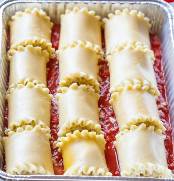 Lasagna Roll-Ups in sauce in a silver baking pan