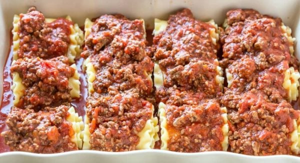 Lasagna Roll-Ups with sauce on top in a baking dish