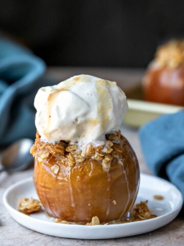 Baked apple filled with oatmeal crisp filling and topped with a scoop of vanilla ice cream