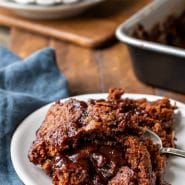 Hot fudge pudding cake on a white dish next to a blue linen napkin