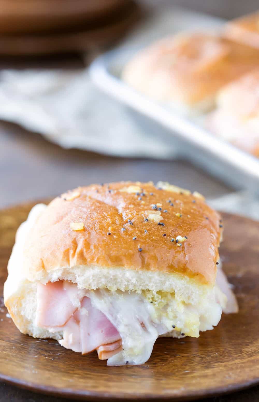 Baked Ham and Cheese slider on a wooden plate