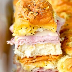 Baked ham and swiss poppy seed sandwich stacked on top of other sandwiches