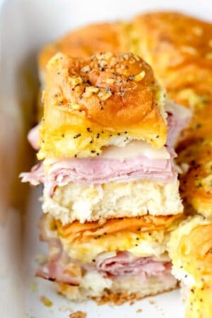 Baked ham and swiss poppy seed sandwich stacked on top of other sandwiches