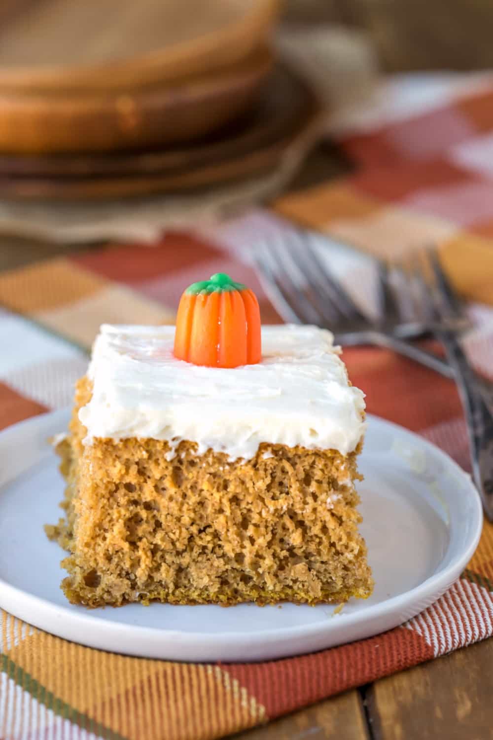 Slice of pumpkin spice cake topped with a candy pumpkin.