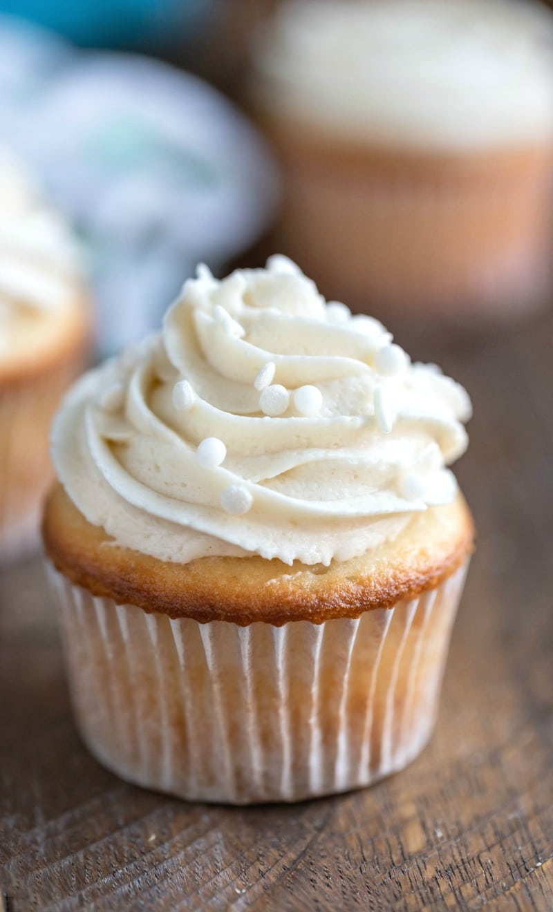 White cupcake topped with vanilla buttercream and sprinkes