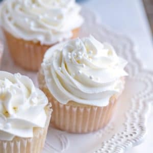 White cupcakes with white frosting on a white plate