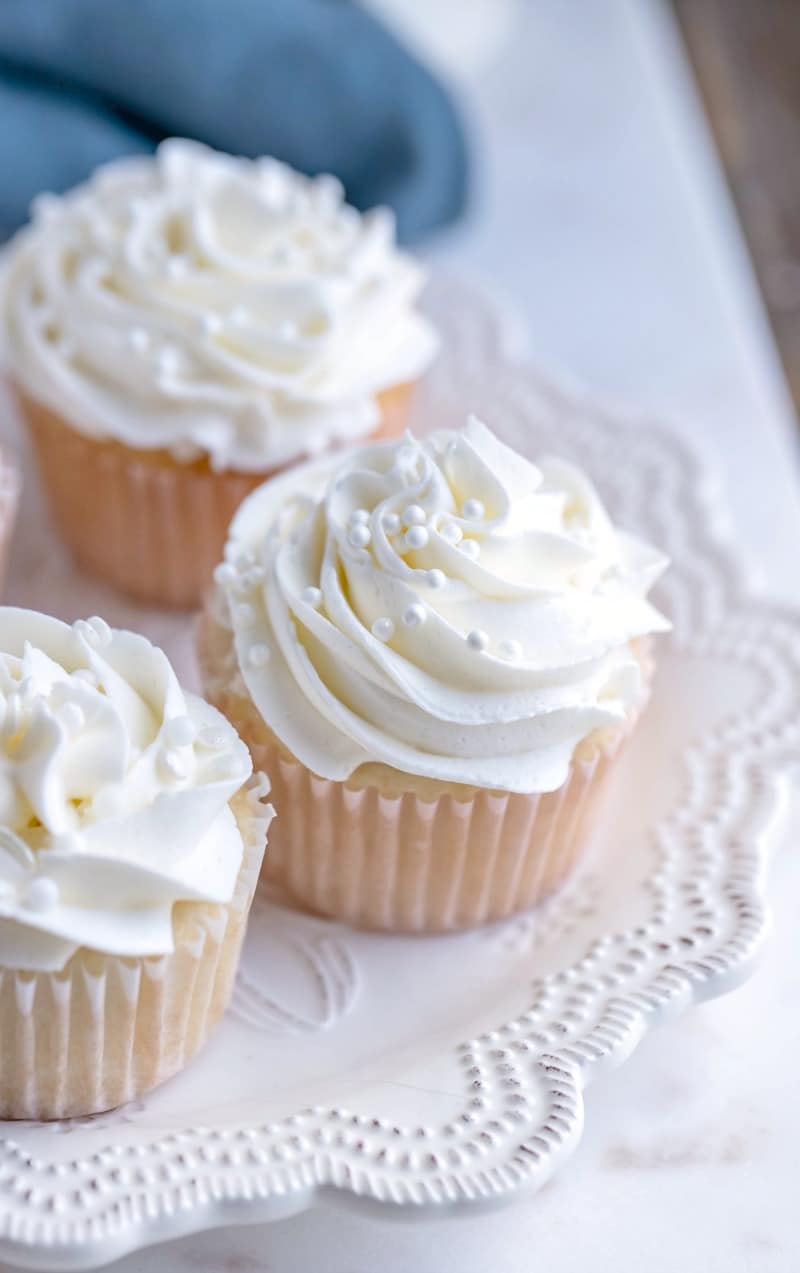 White cupcakes with white frosting on a white plate