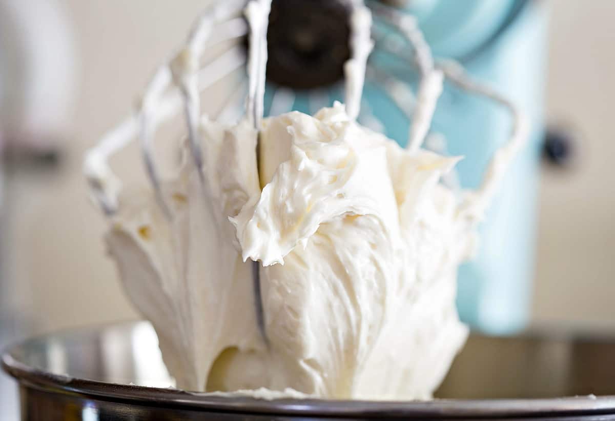 Whipped Buttercream Frosting on a wire stand mixer beater.