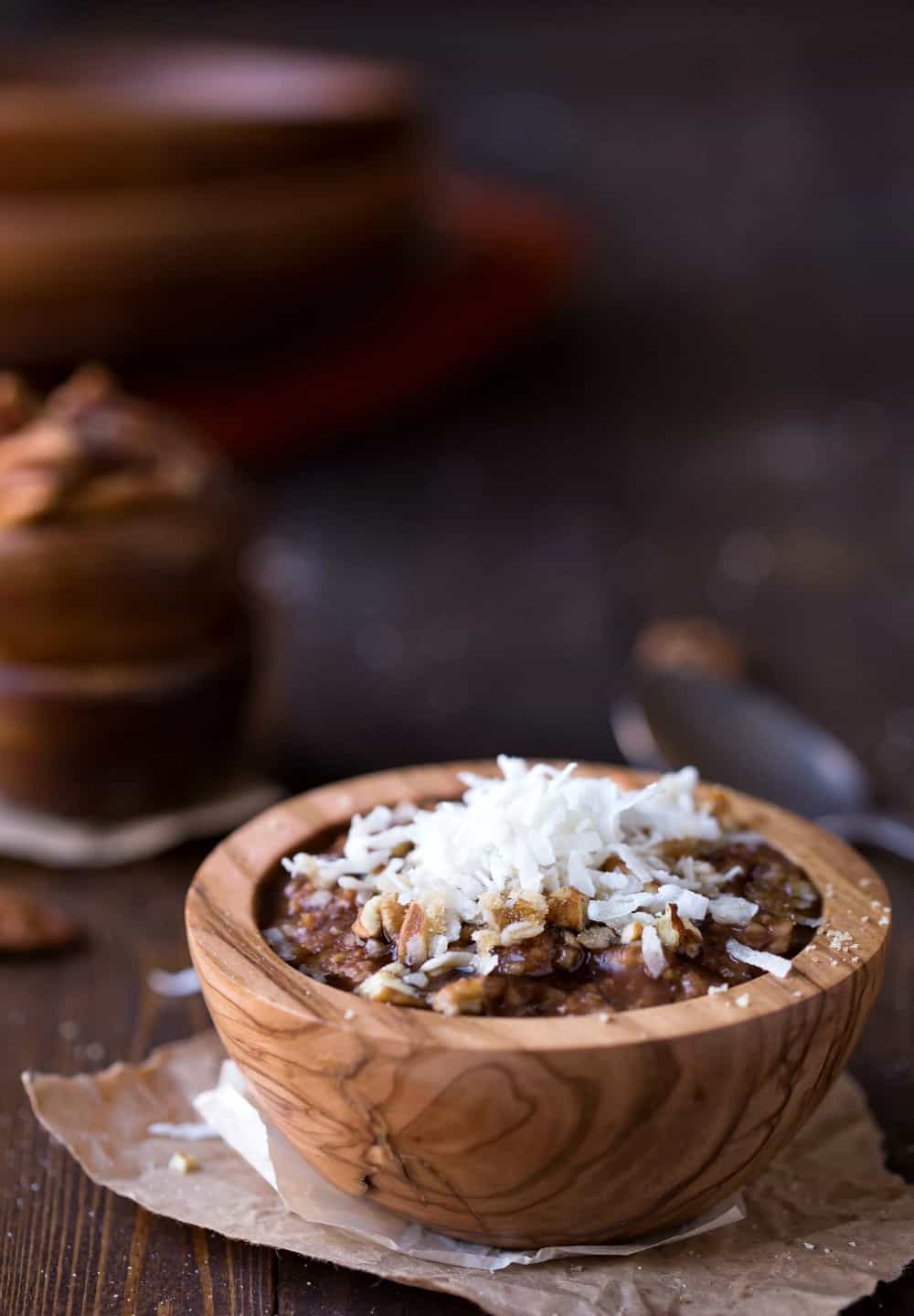Crock Pot German Chocolate Oatmeal topped with coconut in a wooden bowl
