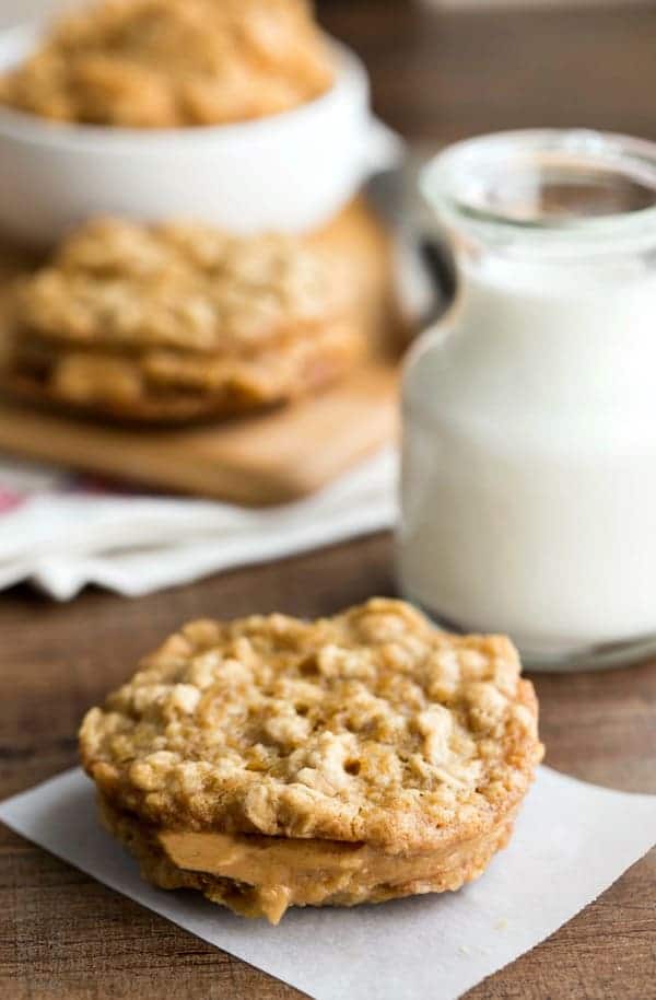 Oatmeal Cookies with Peanut Butter Filling on a piece of parchment paper on a wooden background