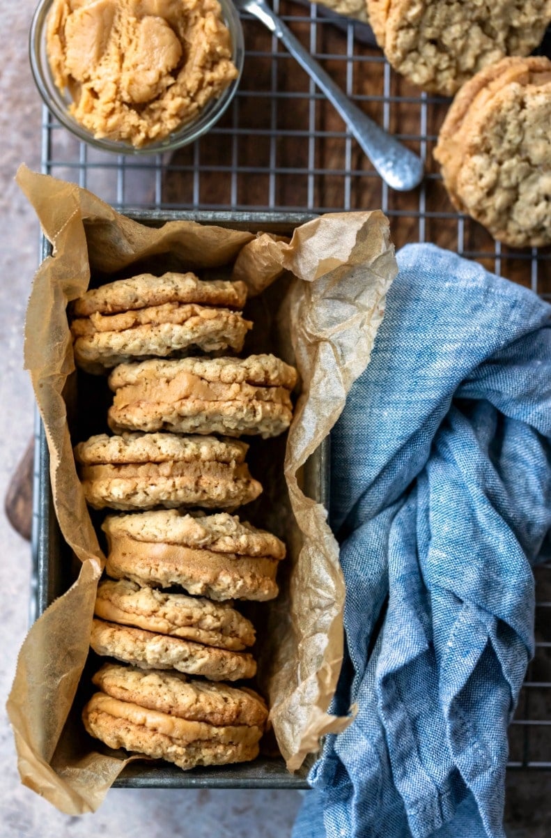 Stack of oatmeal cookies with peanut butter filling in a tin container