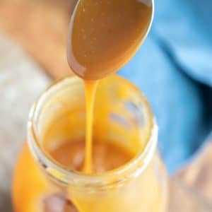Salted caramel dripping off spoon into a glass jar