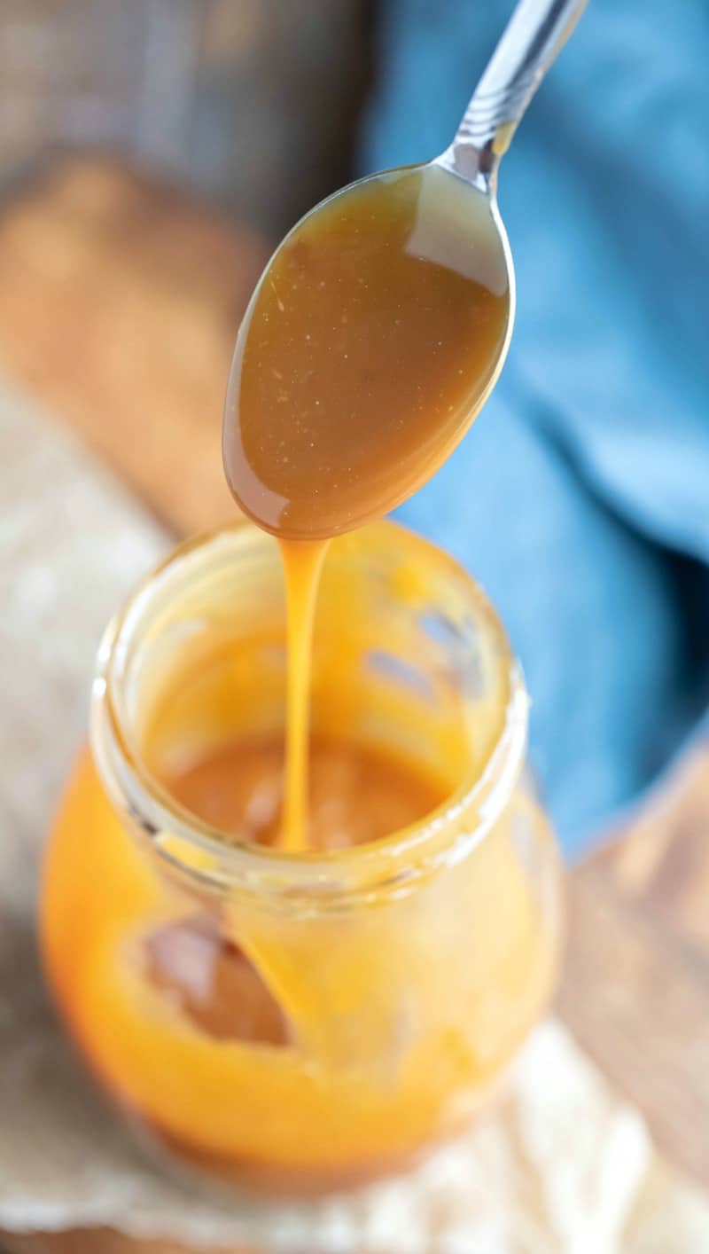 Salted caramel dripping off spoon into a glass jar