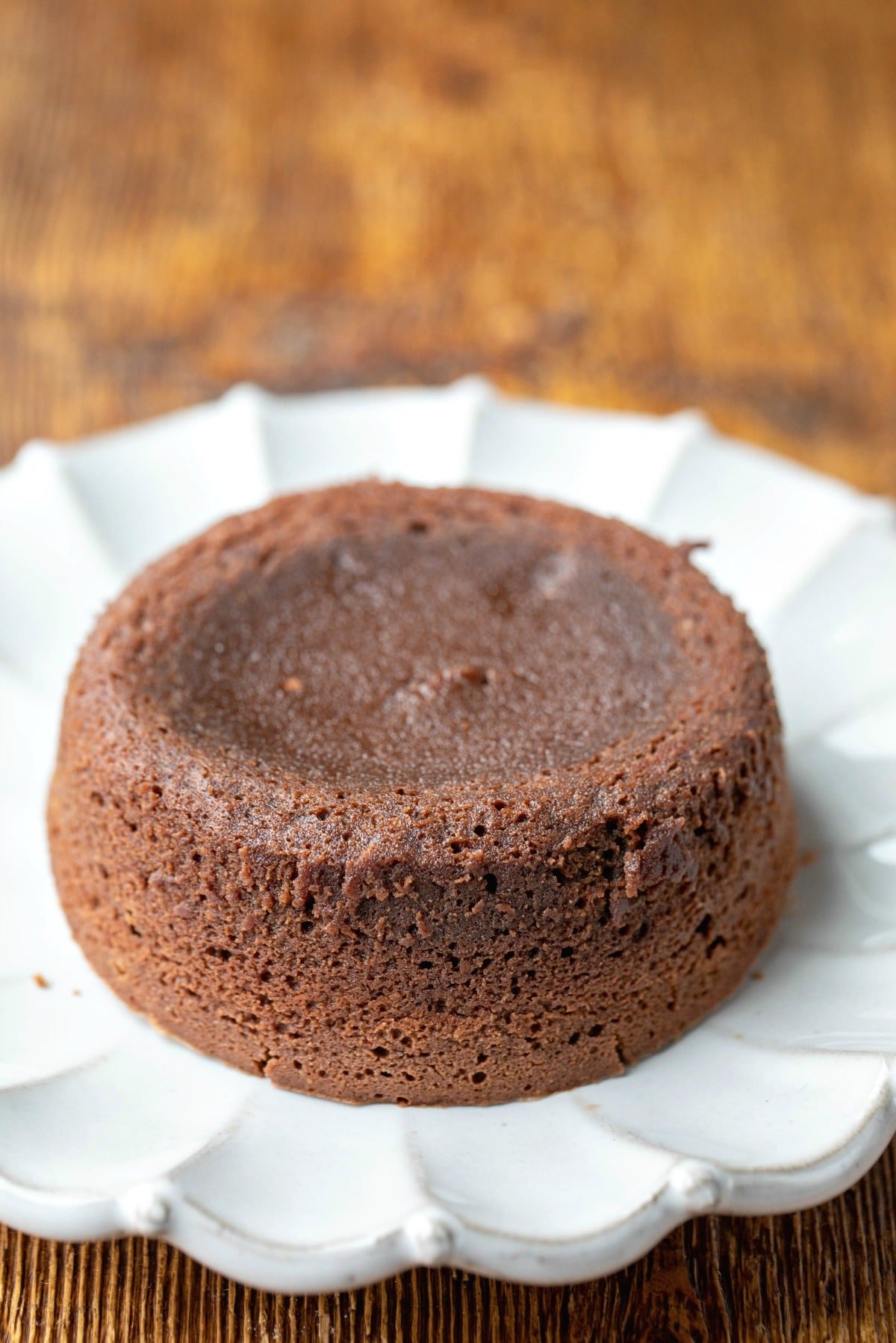 Baked molten chocolate cake on a white scalloped plate