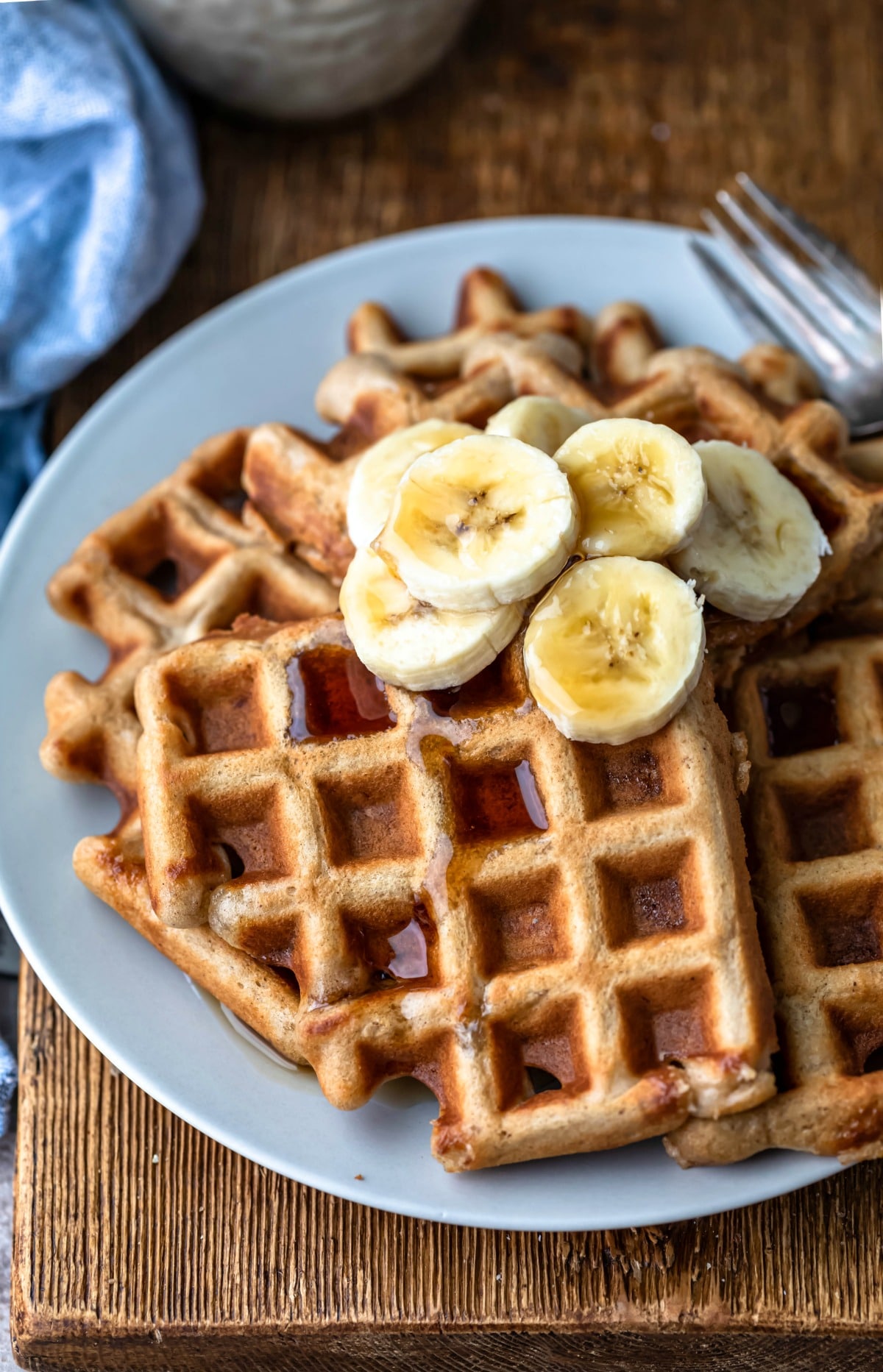 Plate of banana bread waffles topped with sliced bananas