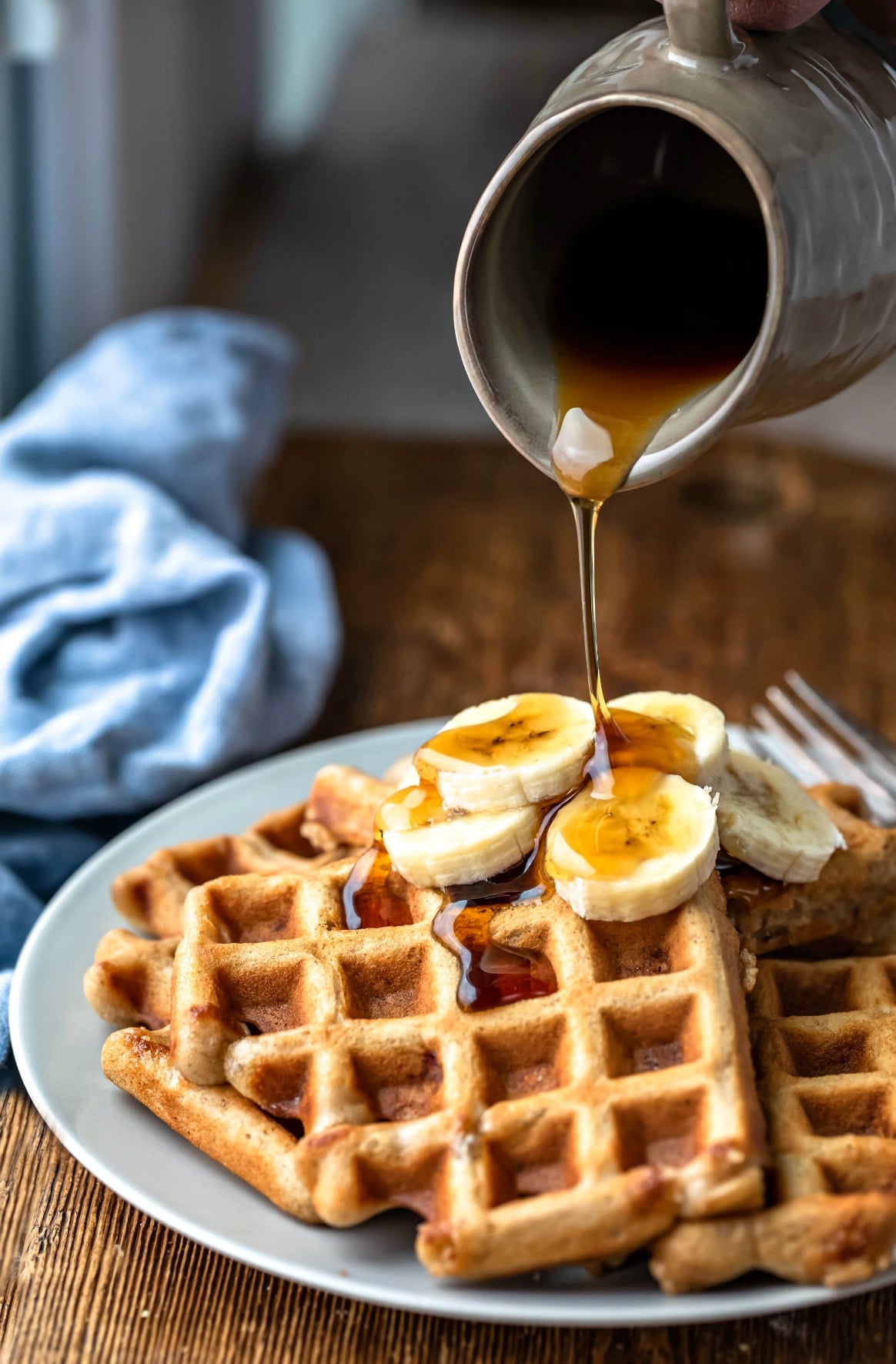 Maple syrup pouring onto banana bread waffles