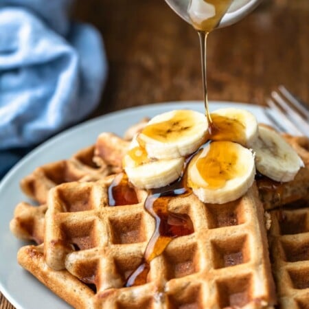 Maple syrup pouring onto slices of banana on banana bread waffles.