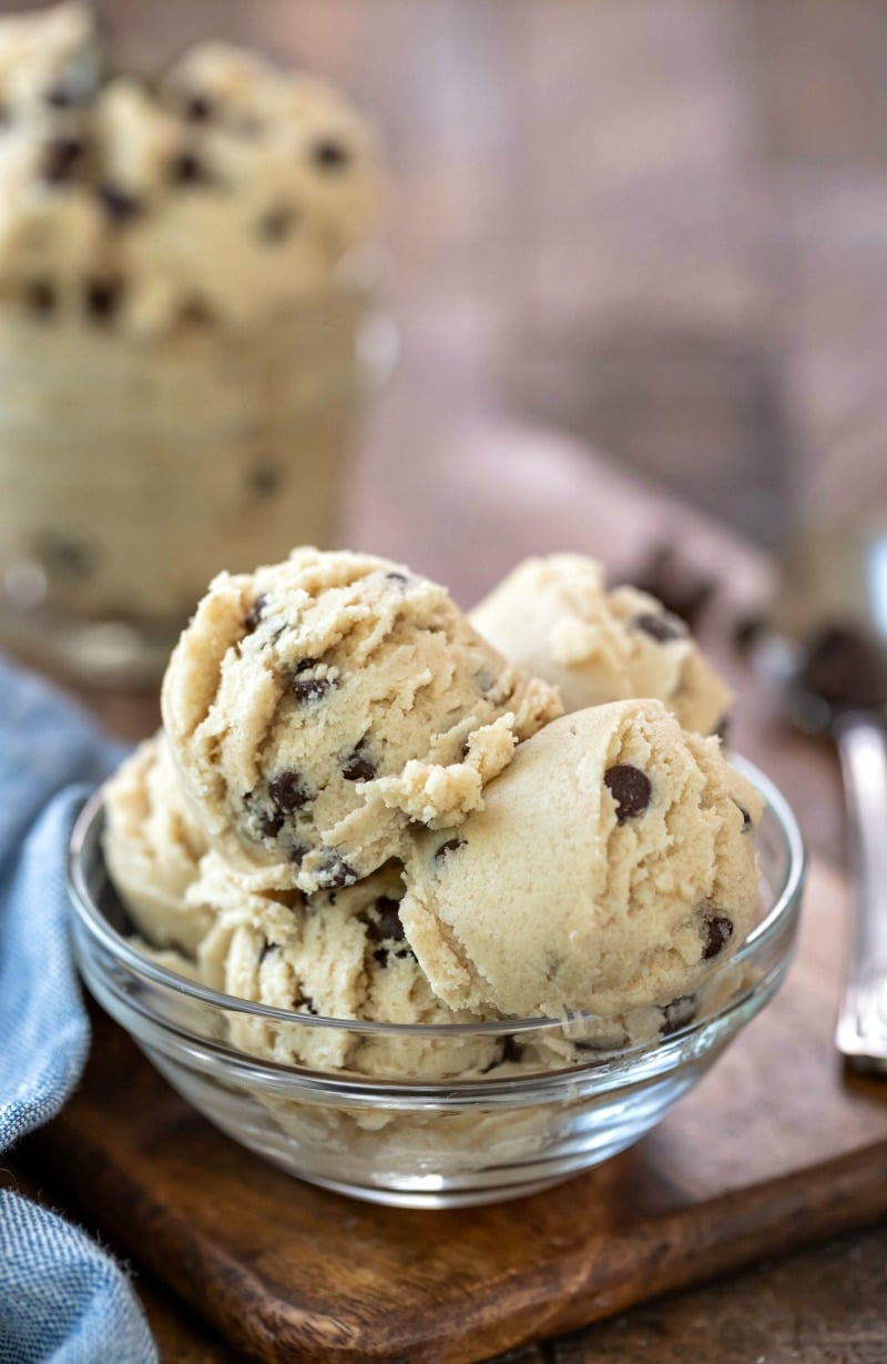 Glass bowl with edible cookie dough next to a blue napkin