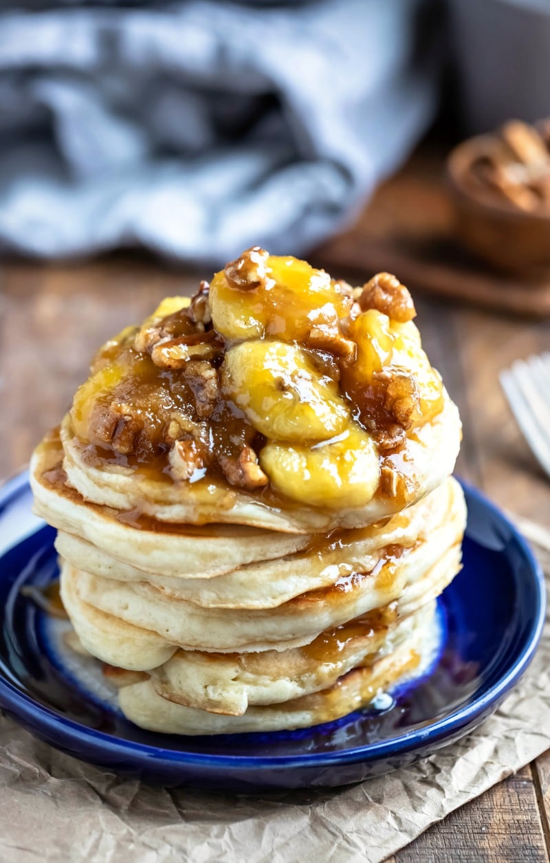 Stack of vanilla pancakes topped with caramelized bananas and pecans