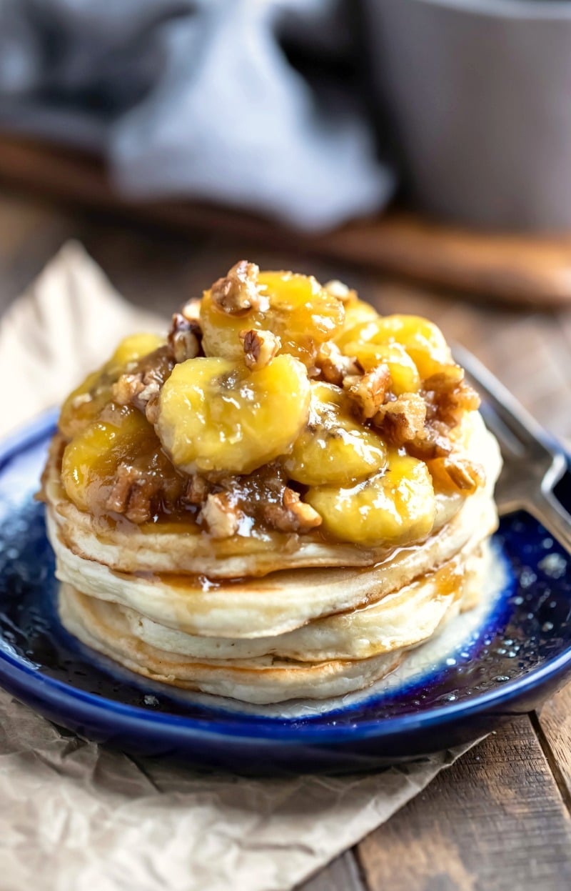 Stack of vanilla pancakes with caramelized bananas on a blue plate