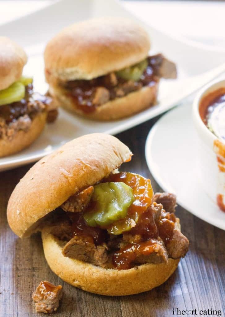 Dr Pepper Brisket Sliders with Dr Pepper BBQ Sauce next to a plate with a bowl of sauce