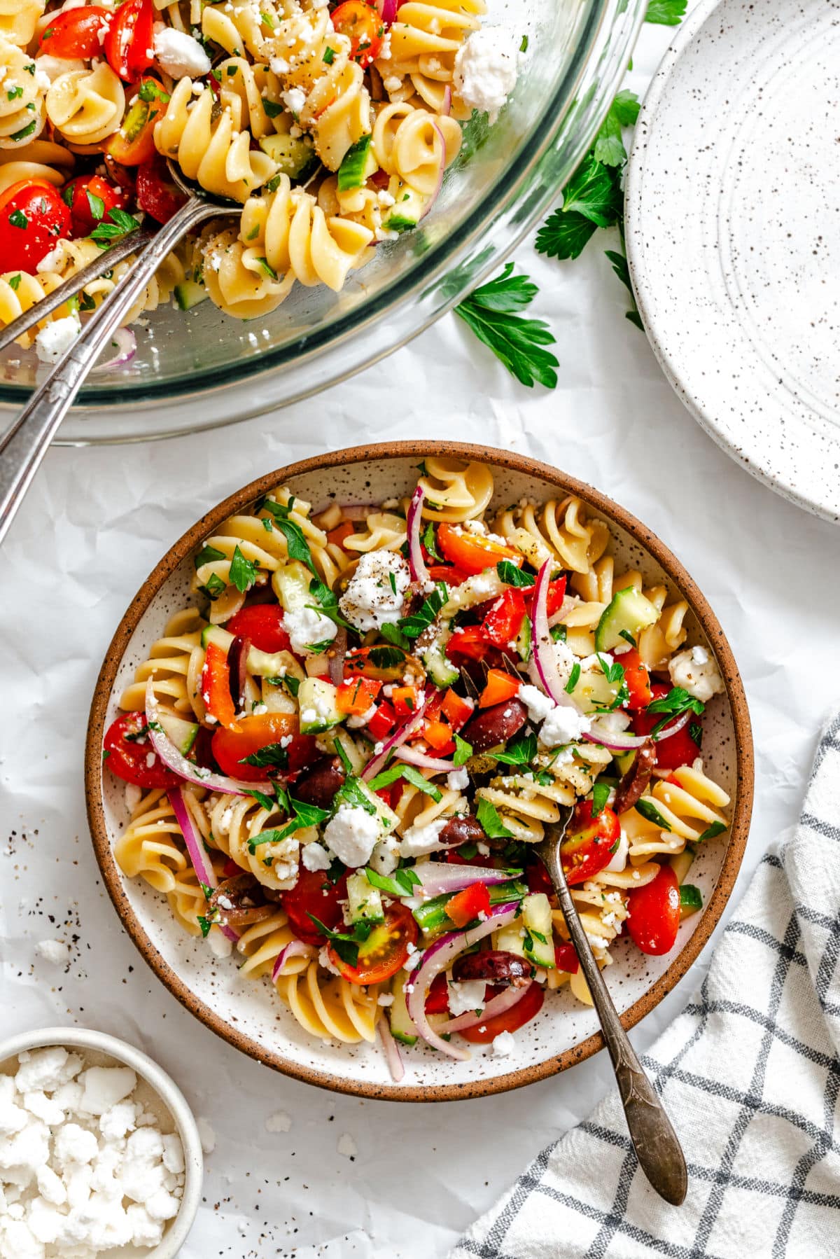 Greek Pasta Salad A dish of Greek pasta salad next to a bowl of the pasta salad.