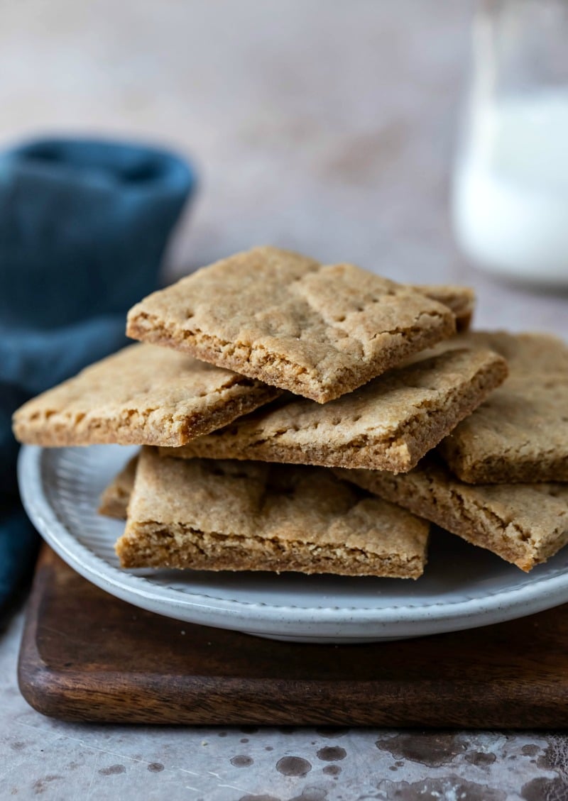 Stack of homemade graham crackers on a cream plate