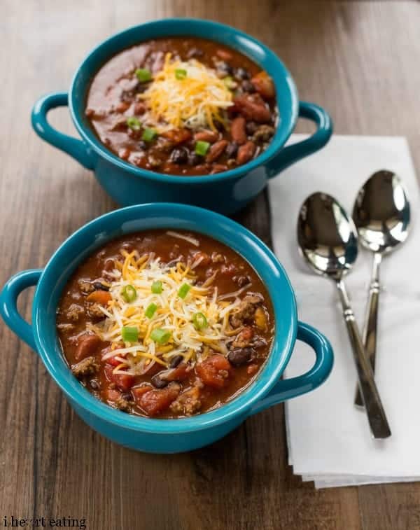 Two bowls of Barbecue Chili next to silver spoons