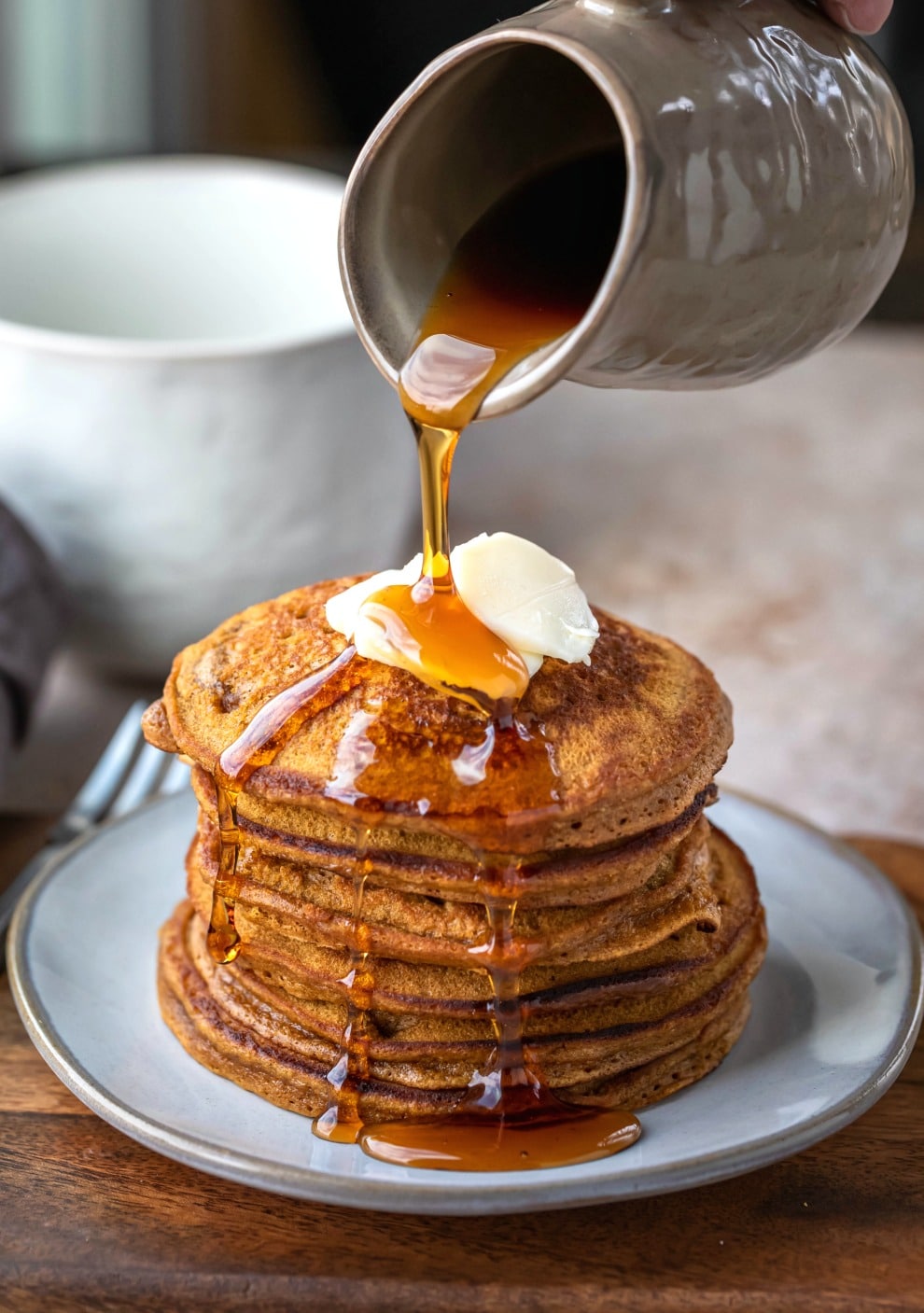 Syrup pouring onto a stack of gingerbread pancakes