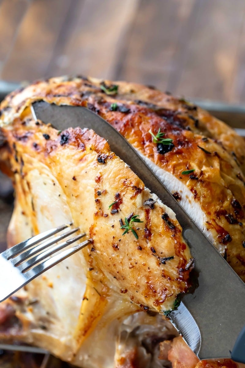 Black knife slicing lemon herb turkey breast