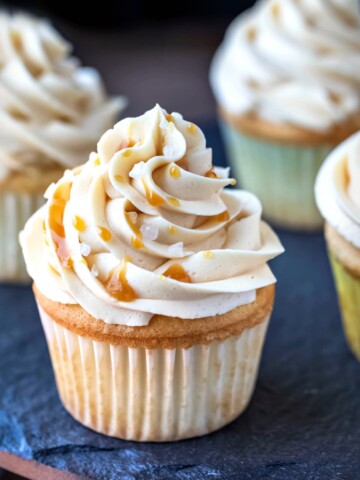 Caramel buttercream frosting topped with caramel sauce and grains of salt.