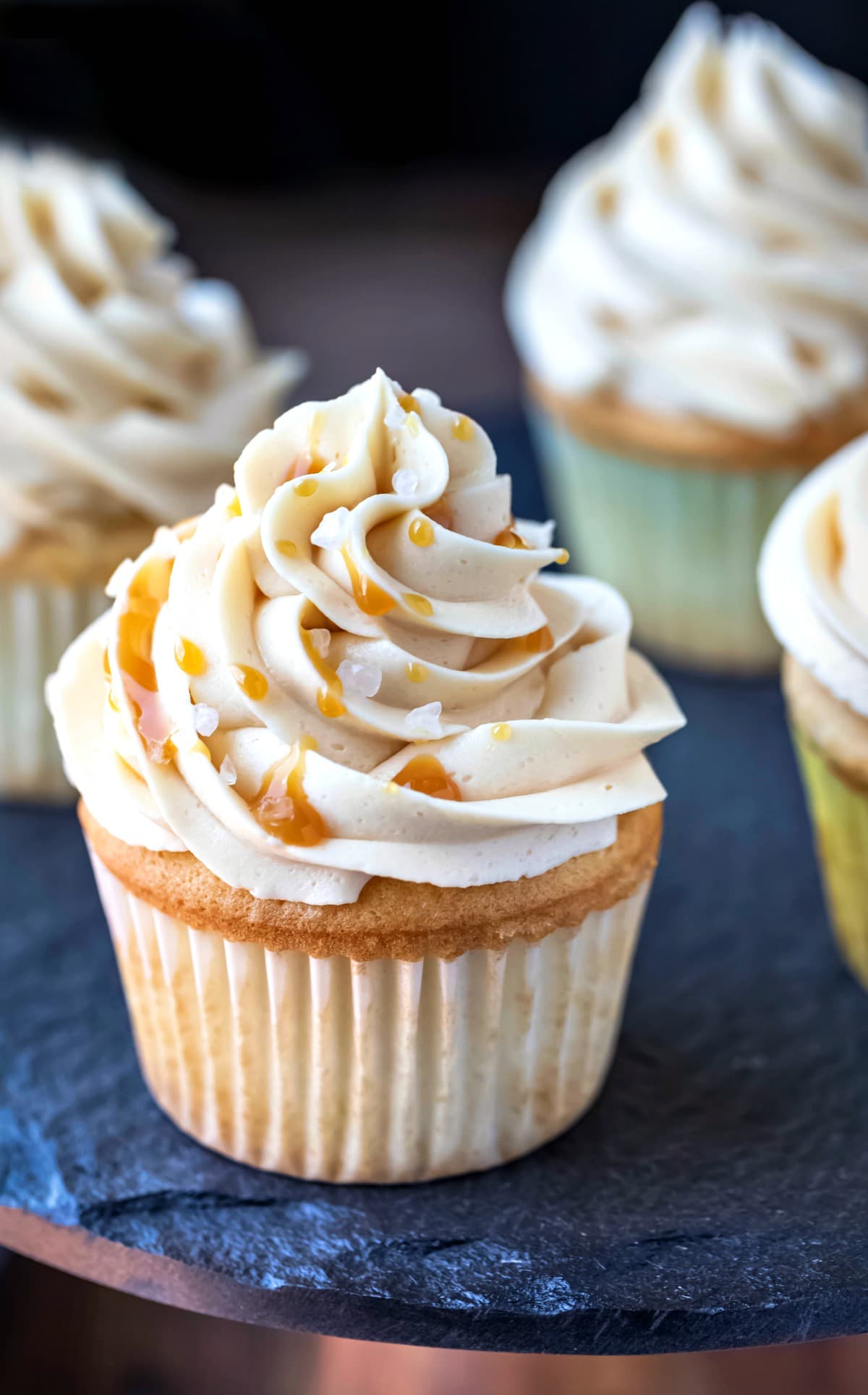 Caramel buttercream frosting topped with caramel sauce and grains of salt.