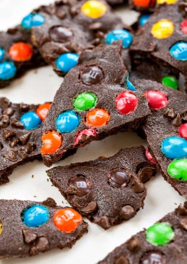 Pieces M&M Brownie Brittle on a piece of white parchment paper