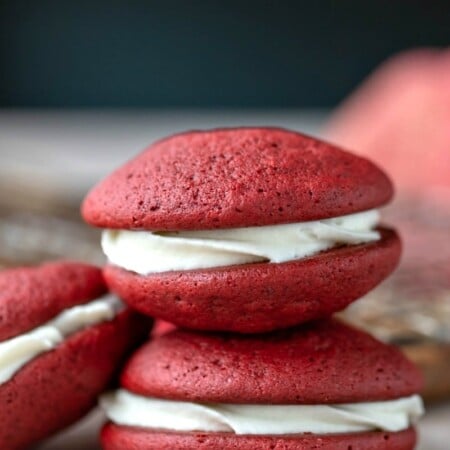 Two red velvet whoopie pies on top of each other.