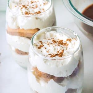 Two glasses of hot chocolate tiramisu on a marble background