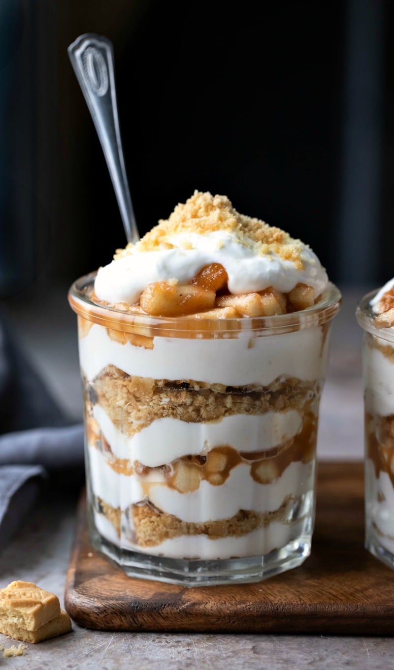 No bake apple pie parfait in a glass jar on a wooden cutting board