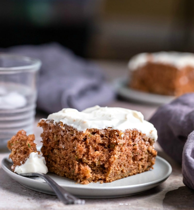 Slice of zucchini cake with a fork and bite of cake next to it