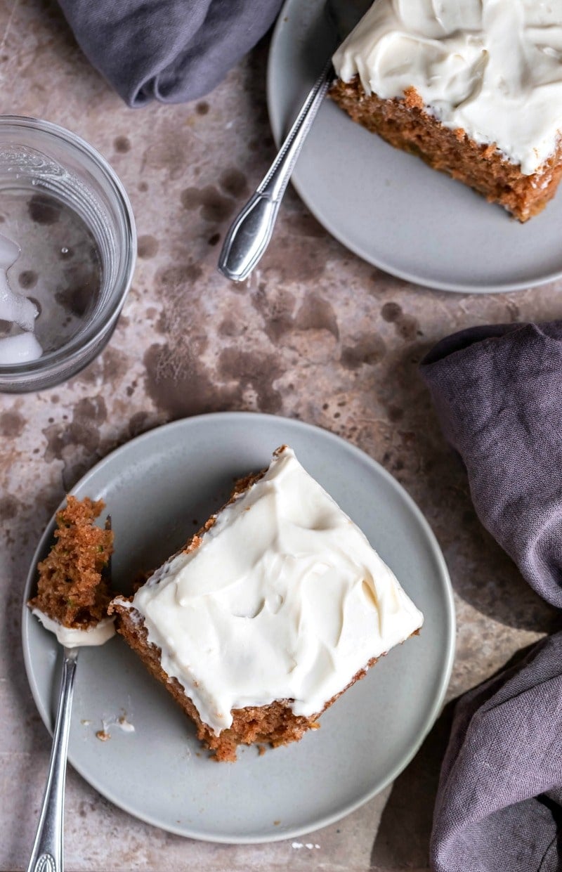 Two slices of zucchini cake on gray ceramic plates