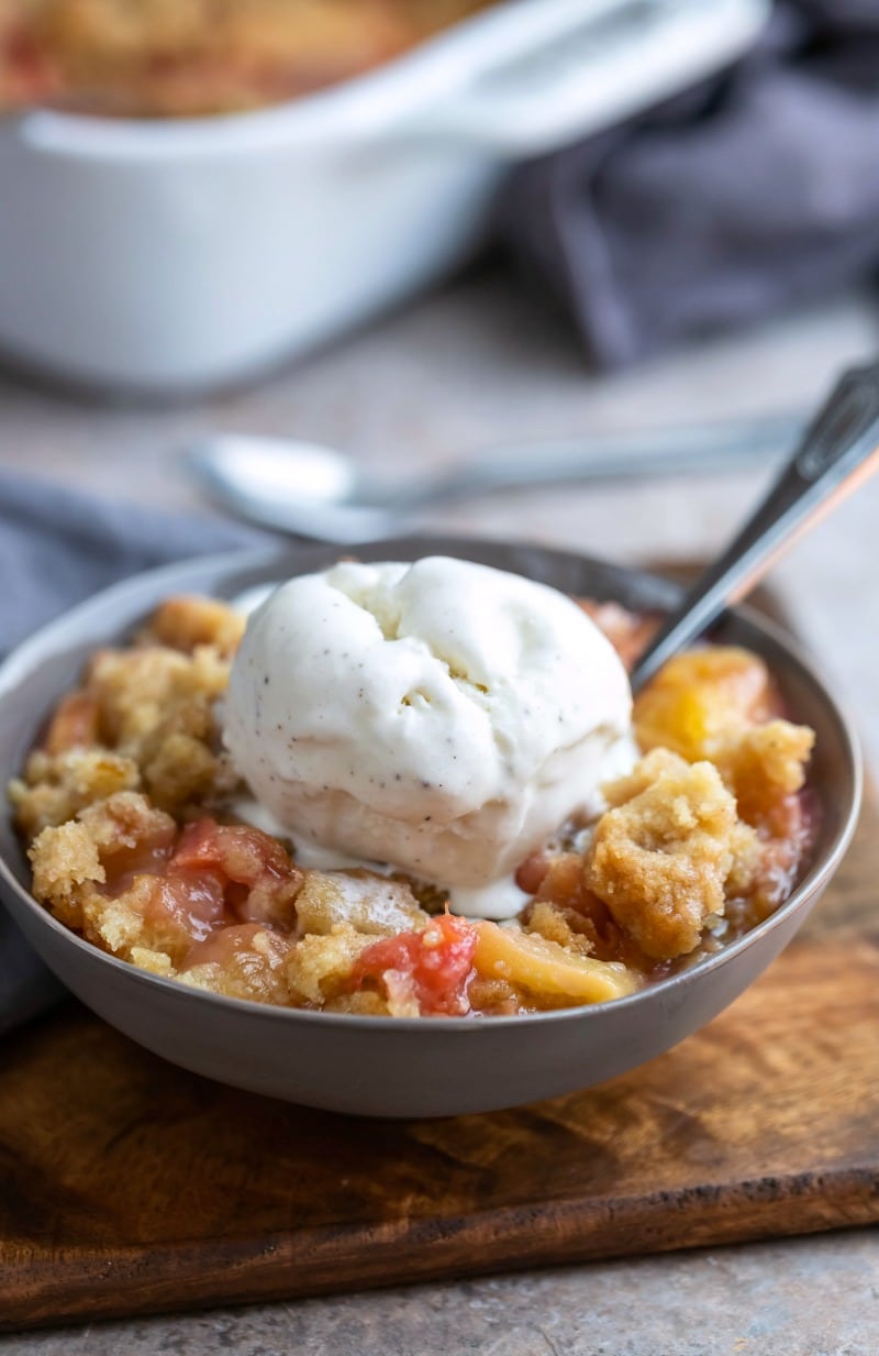Peach crumble topped with a scoop of vanilla ice cream